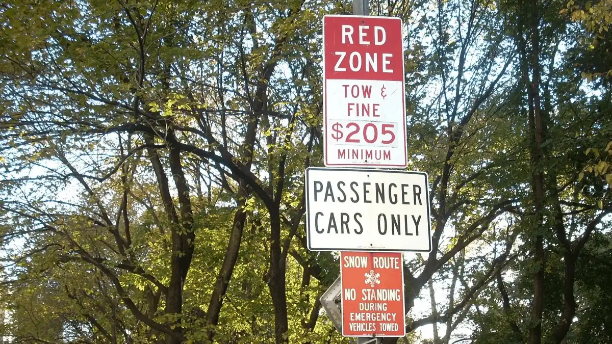 米国の駐車規制標識。「レッドゾーン」「罰金205ドル」「乗用車のみ」「緊急時レッカー移動」の記載あり。
